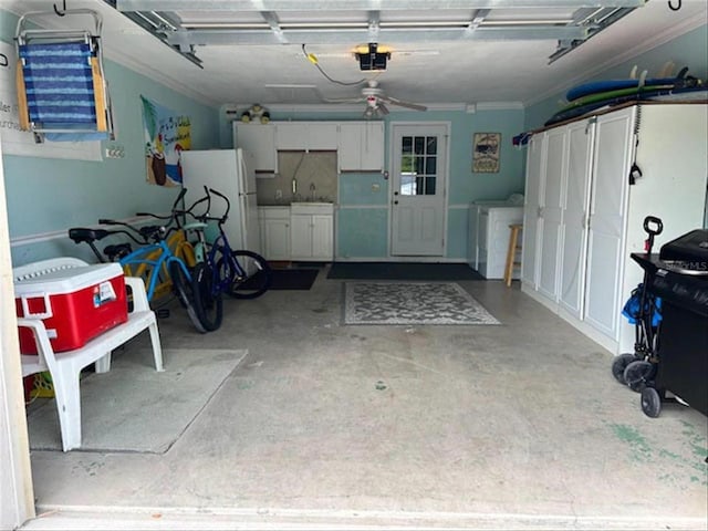 garage with ceiling fan, white refrigerator, sink, and washing machine and dryer