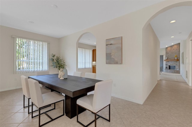 dining room with a large fireplace and light tile patterned floors