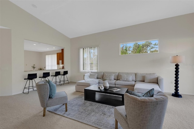 carpeted living room with high vaulted ceiling