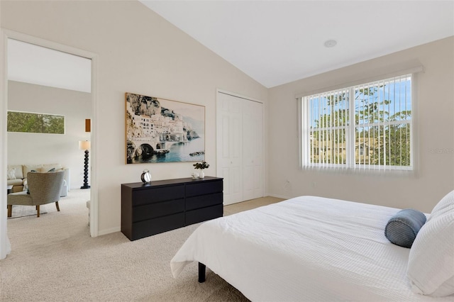 carpeted bedroom with vaulted ceiling and a closet