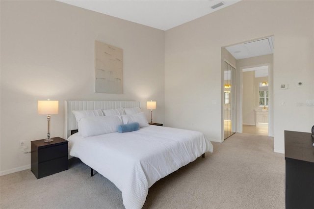 carpeted bedroom featuring ensuite bath