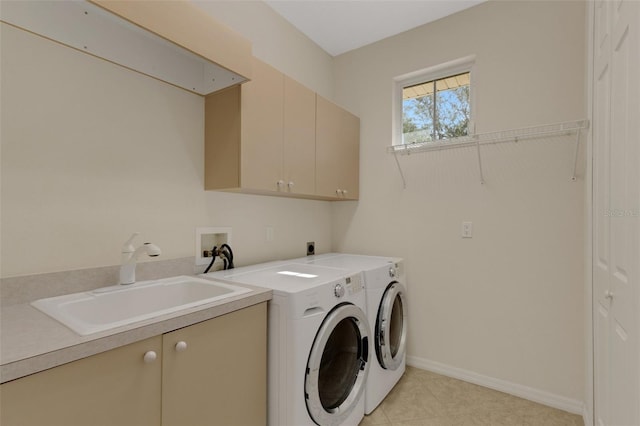 clothes washing area with sink, cabinets, and independent washer and dryer