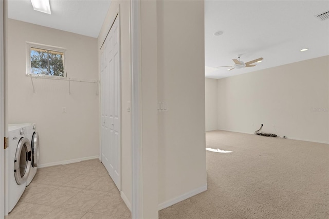 clothes washing area featuring washing machine and dryer, ceiling fan, and light carpet