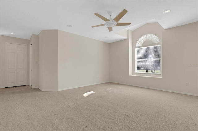 carpeted spare room with lofted ceiling and ceiling fan