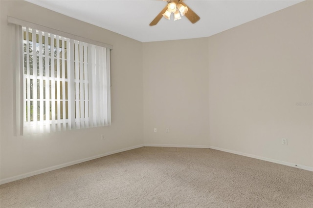 carpeted spare room featuring ceiling fan and plenty of natural light