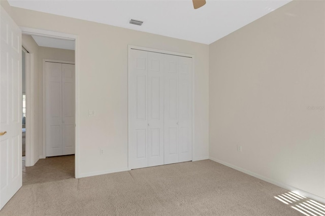 unfurnished bedroom with a closet, ceiling fan, and light colored carpet