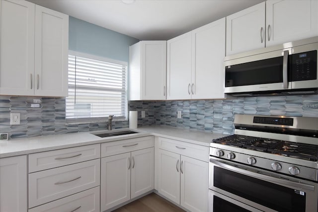 kitchen with tasteful backsplash, sink, stainless steel appliances, and white cabinets