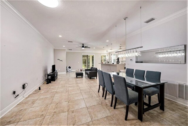 dining room with ceiling fan, ornamental molding, a textured ceiling, and light tile patterned floors