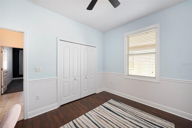 bedroom featuring a closet, dark hardwood / wood-style floors, and ceiling fan