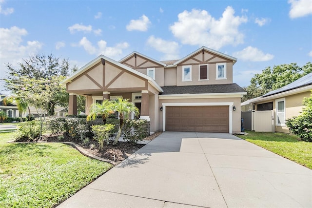 tudor-style house featuring a garage and a front yard