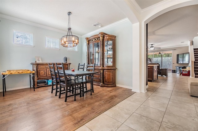 dining space featuring crown molding, ceiling fan with notable chandelier, and light wood-type flooring