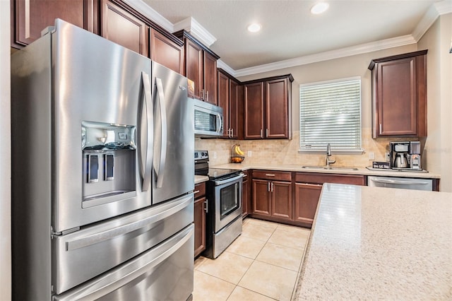 kitchen featuring appliances with stainless steel finishes, light tile patterned floors, ornamental molding, and sink