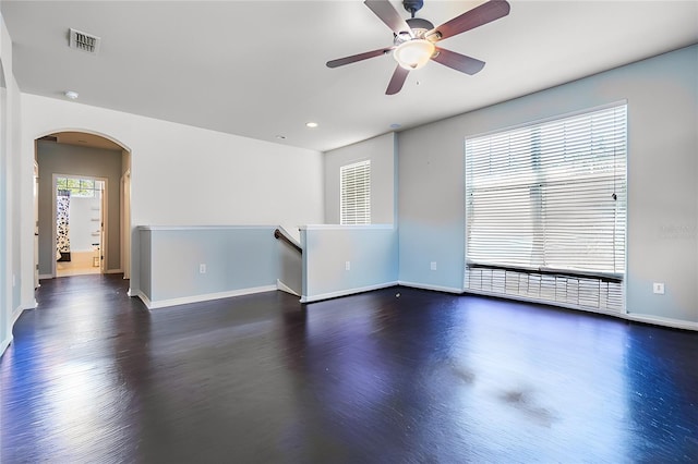 empty room with ceiling fan and dark hardwood / wood-style flooring