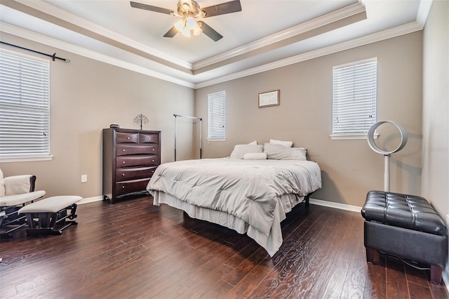 bedroom with dark hardwood / wood-style floors, a raised ceiling, ceiling fan, and ornamental molding