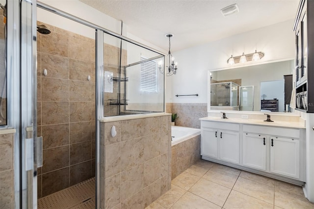 bathroom featuring tile patterned flooring, a chandelier, a textured ceiling, vanity, and independent shower and bath