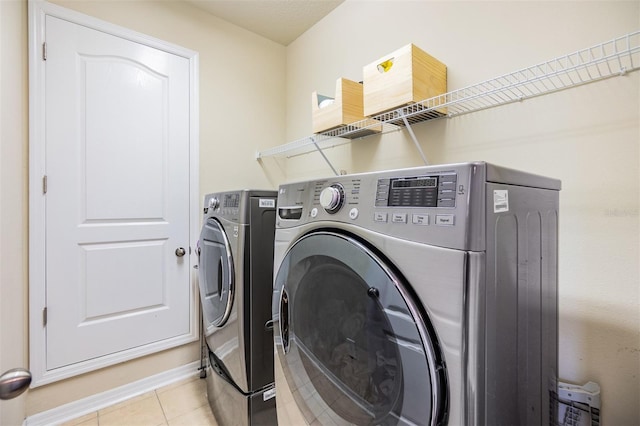 washroom featuring light tile patterned flooring and washing machine and clothes dryer