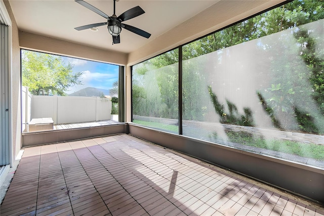 unfurnished sunroom featuring ceiling fan