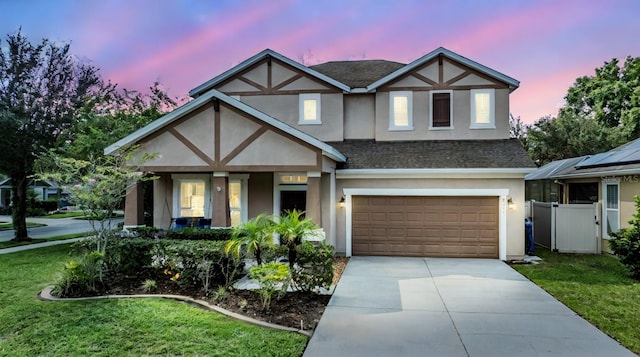 tudor home with a yard and a garage