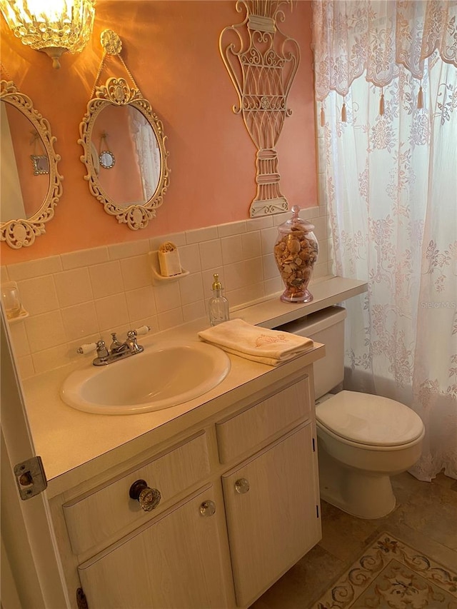 bathroom featuring decorative backsplash, vanity, toilet, and tile patterned floors