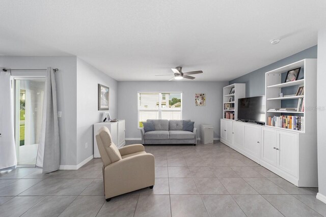 684 SE 65th Ter, Ocala, FL 34472 - living room featuring a ceiling fan, light tile patterned flooring, and baseboards