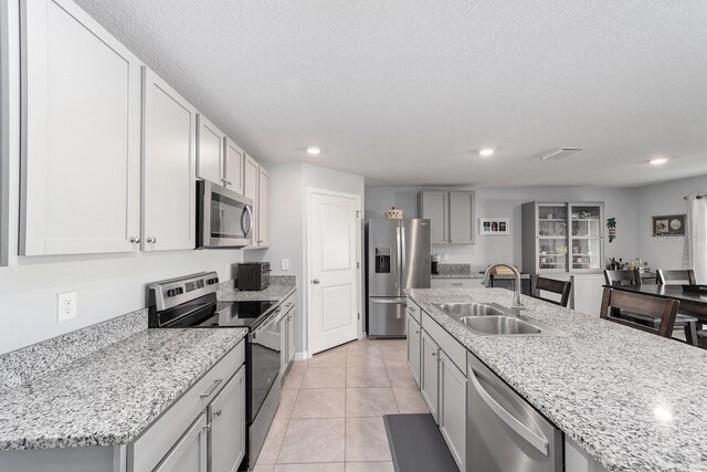 684 SE 65th Ter, Ocala, FL 34472 - kitchen with stainless steel appliances, a sink, recessed lighting, light tile patterned floors, and light stone countertops