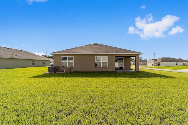 684 SE 65th Ter, Ocala, FL 34472 - rear view of house with a yard, stucco siding, and central air condition unit