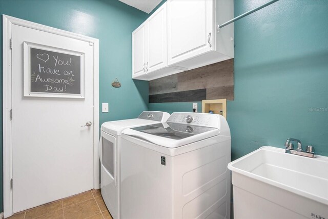 laundry room with washer and clothes dryer, cabinets, sink, and light tile patterned floors