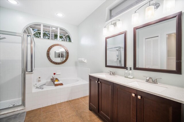 bathroom with independent shower and bath, vanity, and tile patterned floors