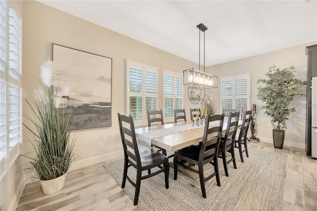 dining area with a chandelier and light hardwood / wood-style flooring