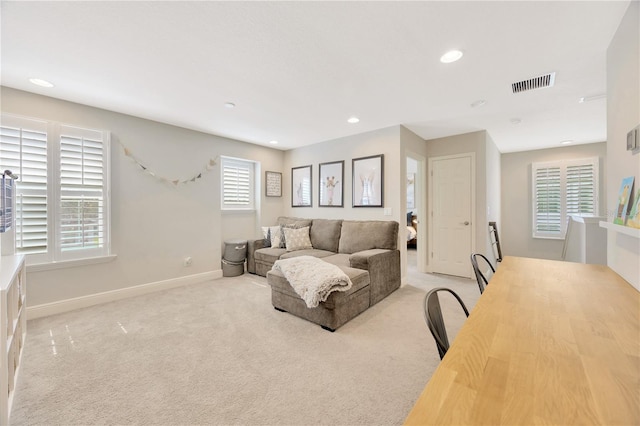 living room with plenty of natural light and light colored carpet