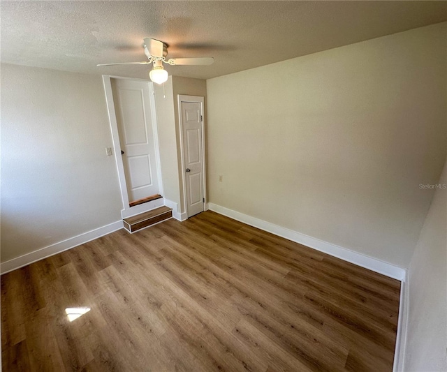 unfurnished room featuring a textured ceiling, hardwood / wood-style floors, and ceiling fan