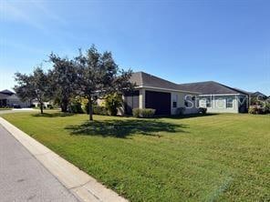 view of side of property featuring a garage and a lawn