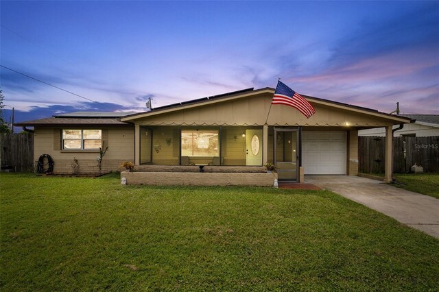 single story home with a garage and a yard