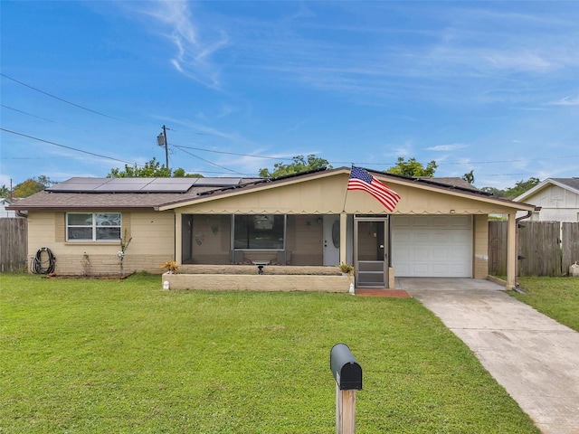 ranch-style home with a front yard, a garage, and solar panels