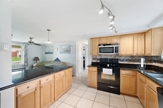 kitchen featuring ceiling fan, stainless steel appliances, hanging light fixtures, and dark stone counters