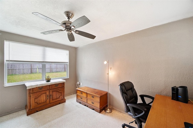 home office featuring ceiling fan and a textured ceiling