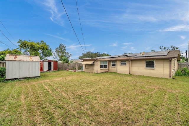 rear view of house with a shed and a yard