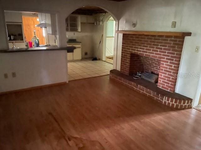 unfurnished living room featuring a fireplace and light hardwood / wood-style flooring