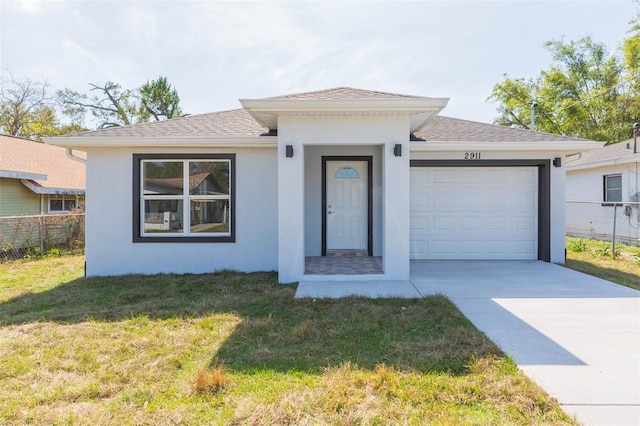 view of front of property featuring a garage and a front lawn