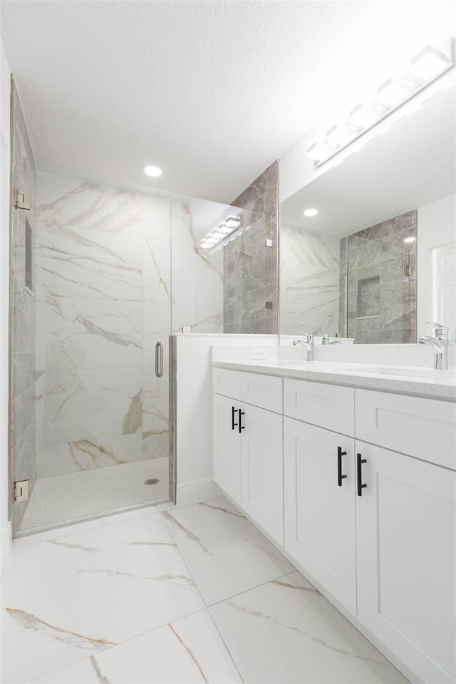 bathroom featuring vanity, a shower with door, and a textured ceiling