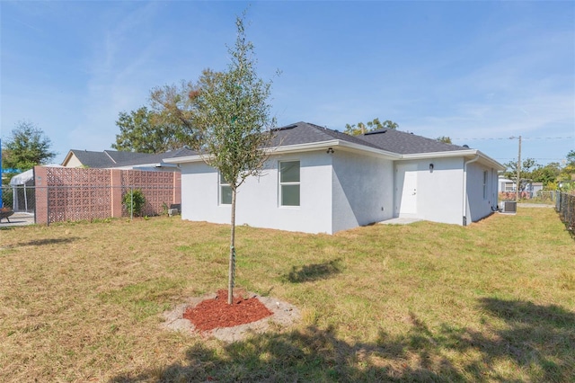 back of house featuring a yard and central AC unit