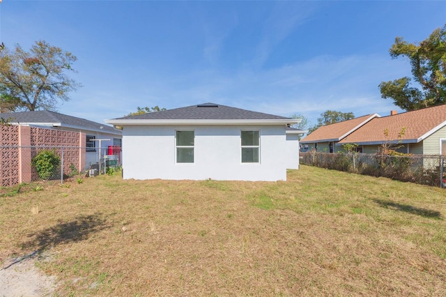 rear view of property with a lawn