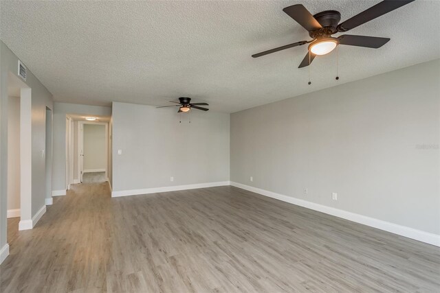 unfurnished room featuring ceiling fan, a textured ceiling, and light wood-type flooring