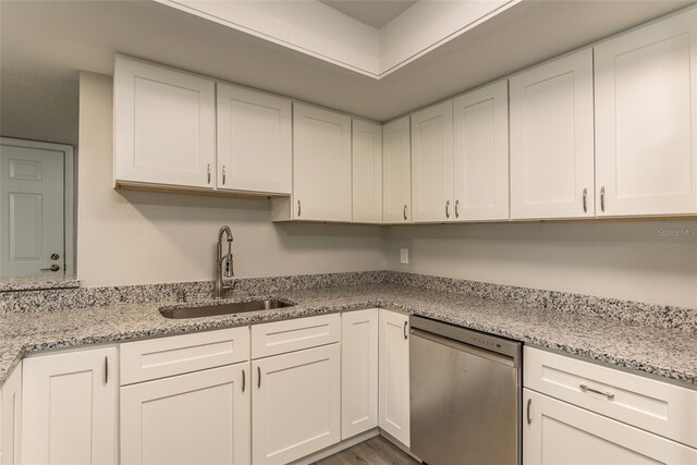 kitchen featuring dishwasher, sink, and white cabinetry