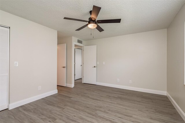 unfurnished bedroom featuring a textured ceiling, hardwood / wood-style floors, and ceiling fan