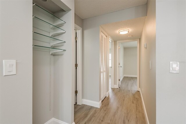 hallway featuring a textured ceiling and light wood-type flooring