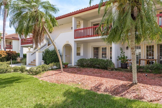 view of front of property featuring a front yard and a balcony