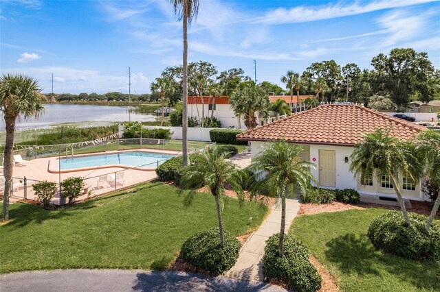 view of swimming pool with a water view and a yard