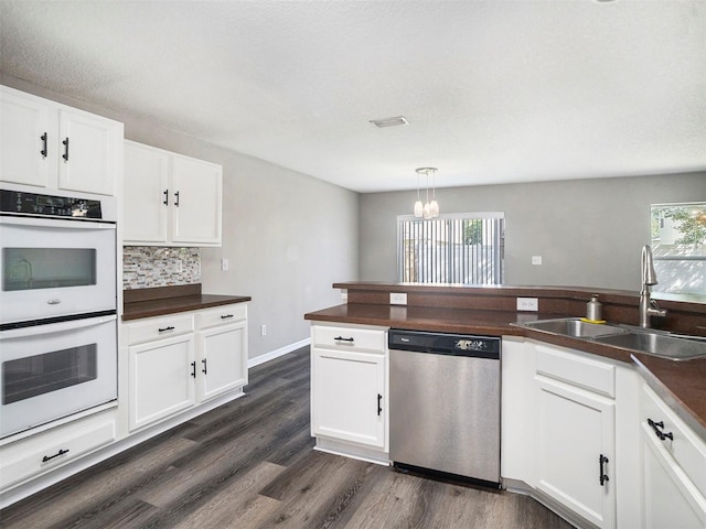 kitchen featuring dishwasher, white cabinetry, white double oven, and sink