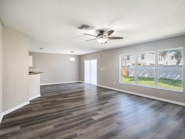 unfurnished living room with dark wood-type flooring, ceiling fan, and a textured ceiling